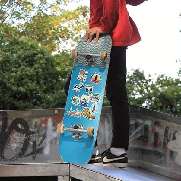A person holds a blue surfboard decorated with fishing theme vinyl stickers.