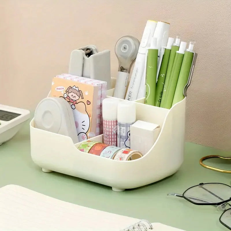 A white five-compartment desktop organizer holding various pens, pencils, and office supplies.