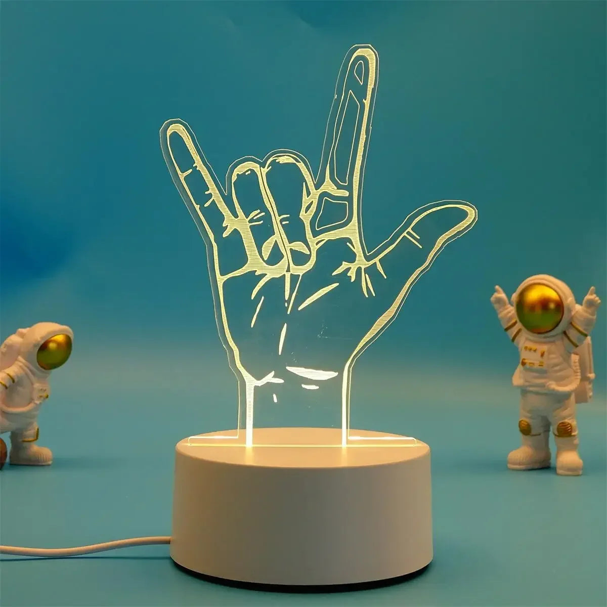 A glowing hand gesture sign is displayed on a white base, with a small astronaut figure in the background.