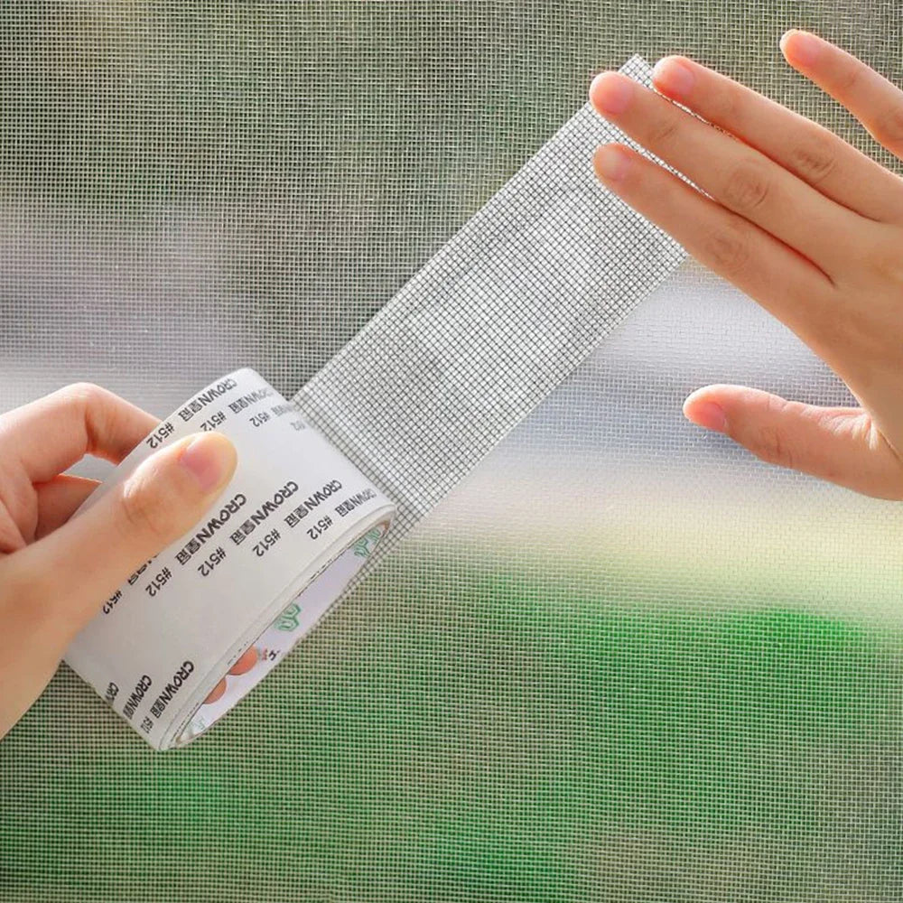 Eine Hand appliziert oder inspiziert Reparaturklebe für ein Moskitonetz auf einem Fenstergitter.