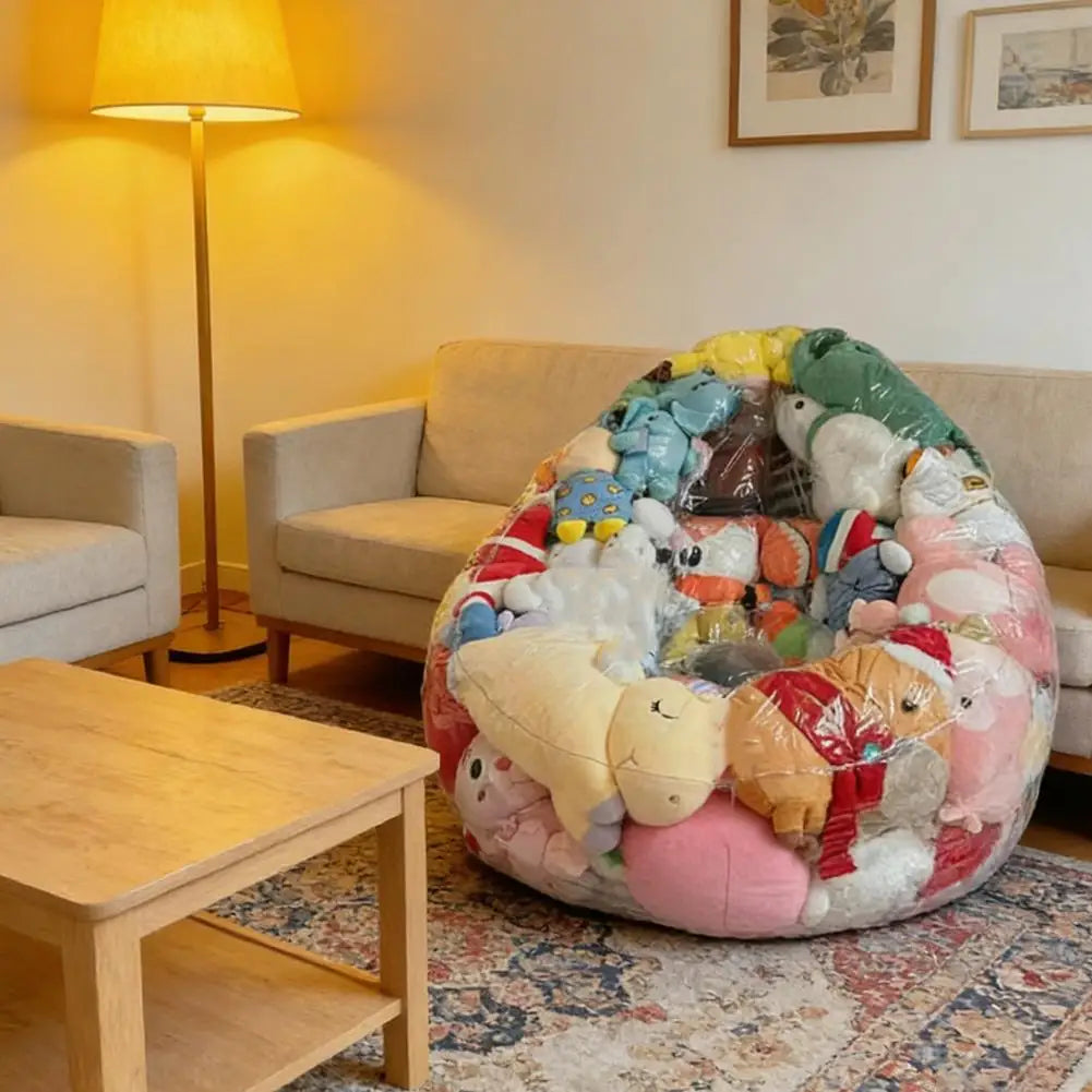 A large, colorful inflatable plush toy storage bag resting on a rug next to a wooden table.
