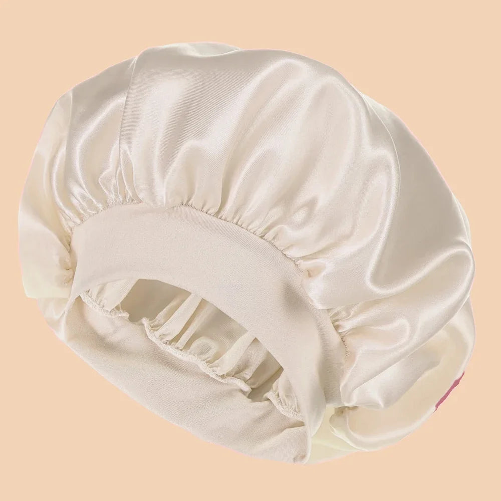 A white satin wide brim shower cap is shown from above, folded and draped.