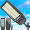 A solar-powered outdoor security light with a motion sensor and remote control is shown angled against a blue sky.