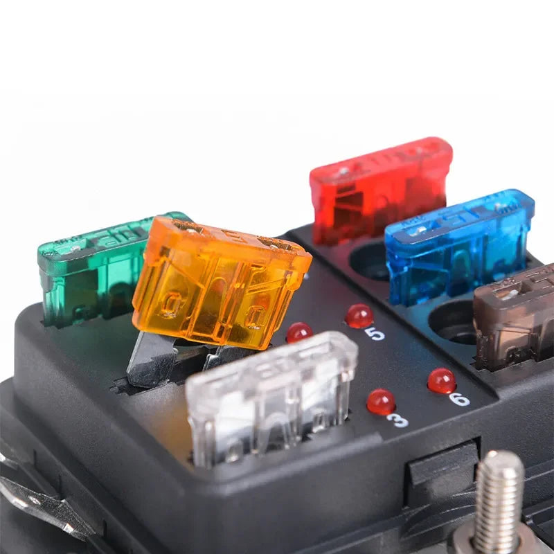 Assortment kit of various blade fuses in different colors stored in a black plastic box.