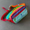 A colorful unisex water-resistant crossbody chest bag with multiple colored fabric panels and a red strap.