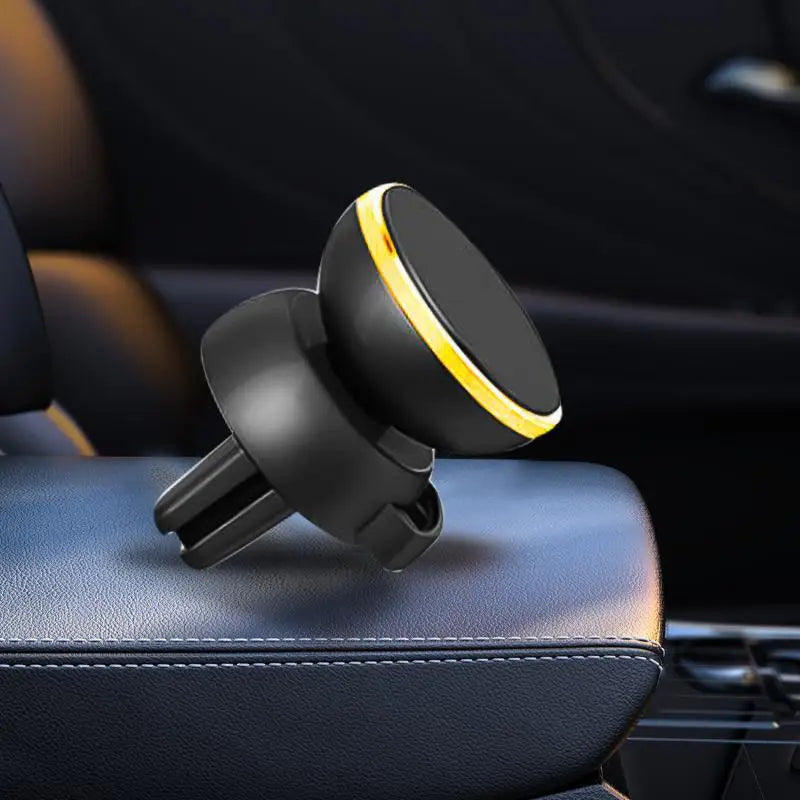 Support de téléphone magnétique noir avec accent jaune posé sur un siège de voiture en cuir foncé.