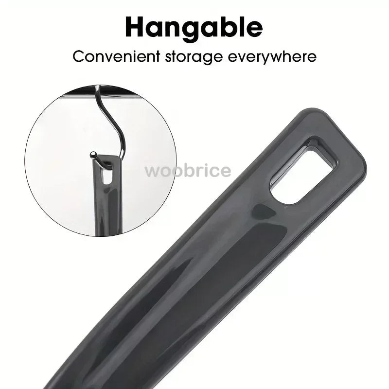 A close-up view of a black, hangable crevice cleaning brush with a flexible cleaning tip.