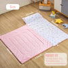 A pink quilted toddler nap mat with a removable pillow and fleece blanket shown on a wooden floor.