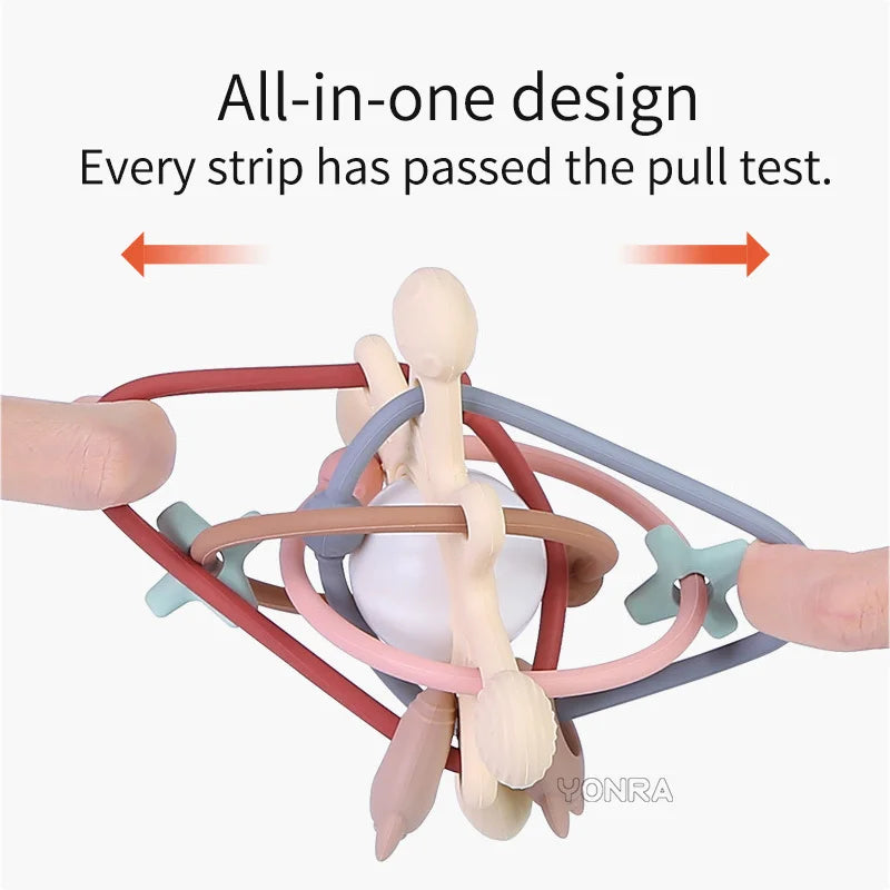 An all-in-one silicone sensory rattle ball with multiple colored strips being pulled to demonstrate strength.
