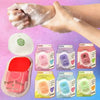 A hand is applying a white soap to the skin, with various packaged paper soaps visible below.