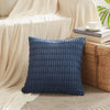 A dark blue corduroy pillowcase with a textured striped velvet design resting on a light beige fabric.