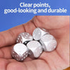 A hand holds five silver metal dice on a blue background.