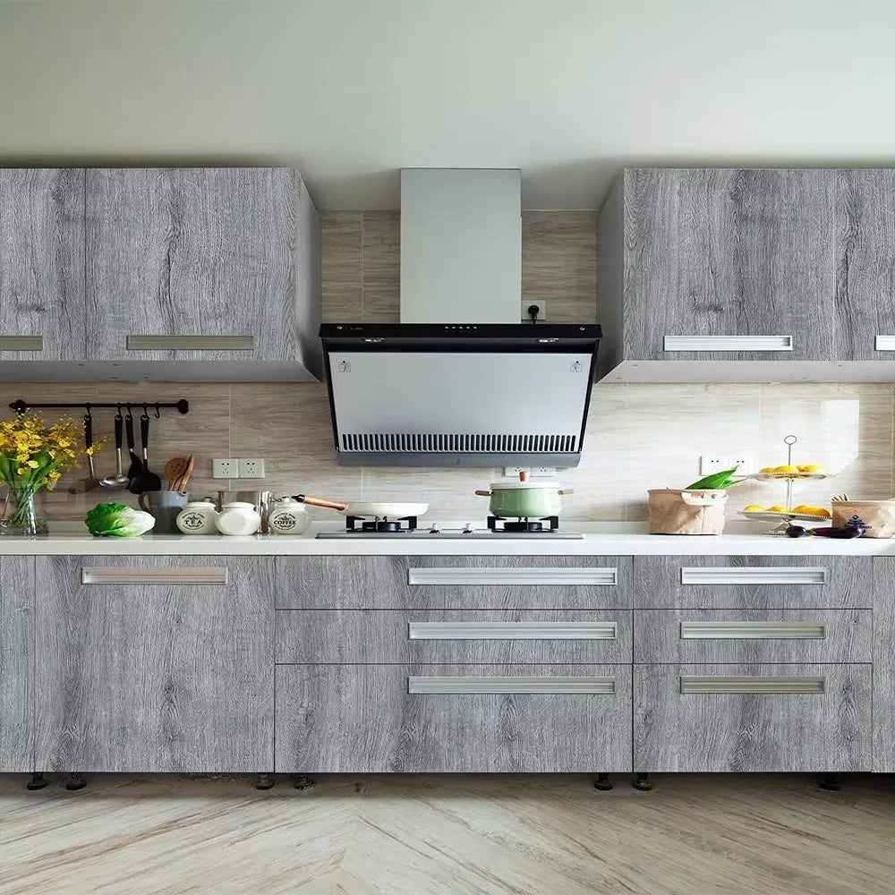 Modern kitchen cabinetry featuring gray wood grain vinyl wallpaper and stainless steel appliances.