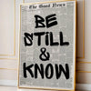 Framed canvas wall art featuring a vintage newspaper style quote that reads Be Still & Know