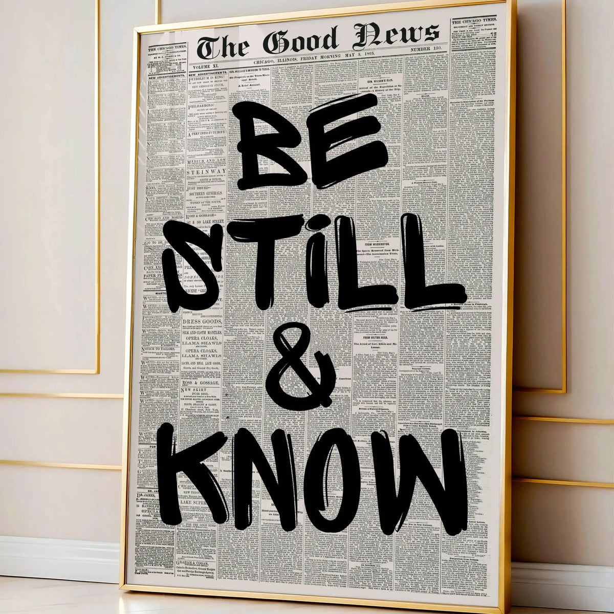 Framed canvas wall art featuring a vintage newspaper style quote that reads Be Still & Know