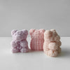 Three handmade silicone bear figures in lavender, pink, and peach tones arranged on a white surface.