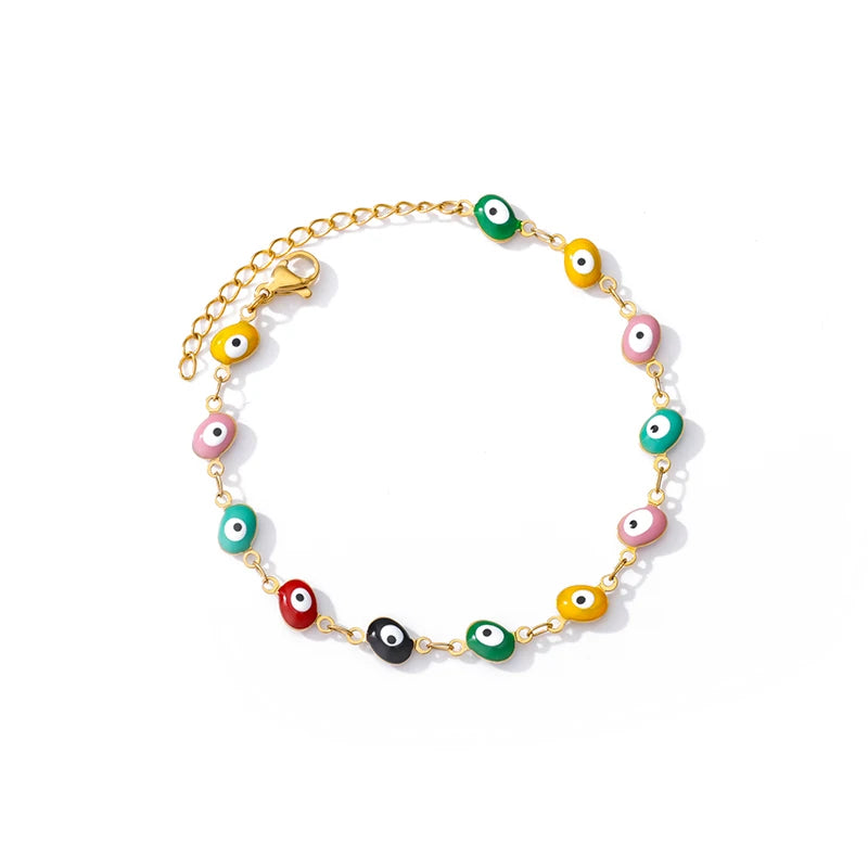 Goldene Armbandkette mit verschiedenen Amuletten im Evil-Eye-Design auf weißem Hintergrund.