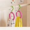 A set of pink and green wall-mounted hooks for organizing hats and scarves.