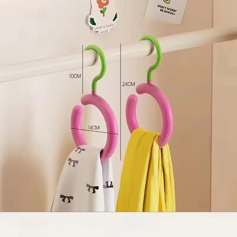 A set of pink and green wall-mounted hooks for organizing hats and scarves.