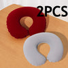 Two inflatable U-shaped travel neck pillows in red and gray on a wooden surface.