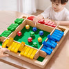 A wooden shut the box dice game with colored wooden blocks and dice set on a green board.