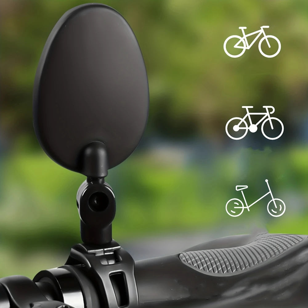 A close-up view of a black 360° adjustable bicycle rearview mirror mounted on a bike handlebar.