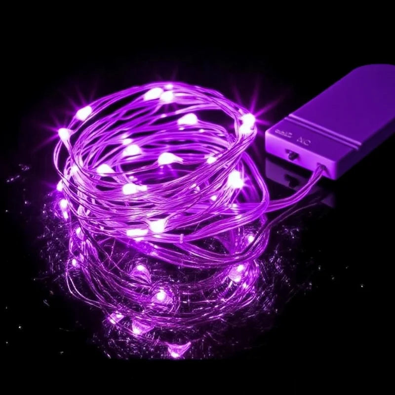 سلسلة متشابكة من أضواء خيطية زهرية تضيء جهازًا إلكترونيًا صغيرًا.