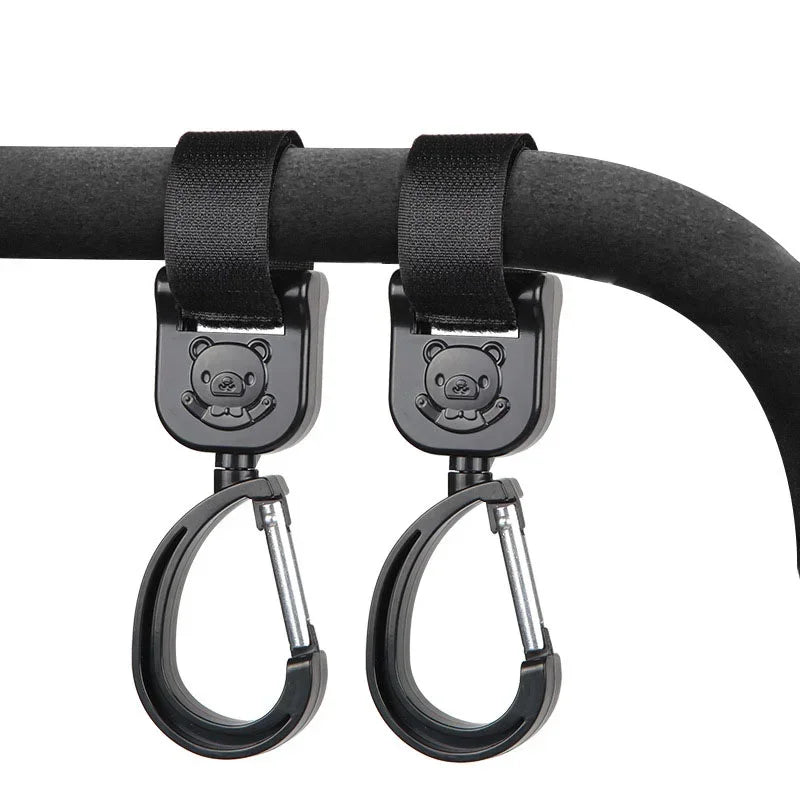 Black rotating hooks designed for hanging bags and essentials on a stroller bar.