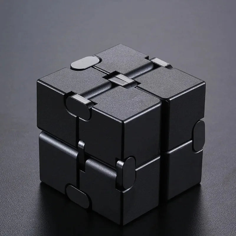 A black metal infinity fidget cube with interlocking pieces, shown from above.