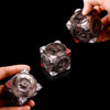A hand holds a premium metal spinner dice cube, showing its intricate design and metallic finish.