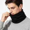 A man wearing a black neck warmer scarf over a gray sweater.