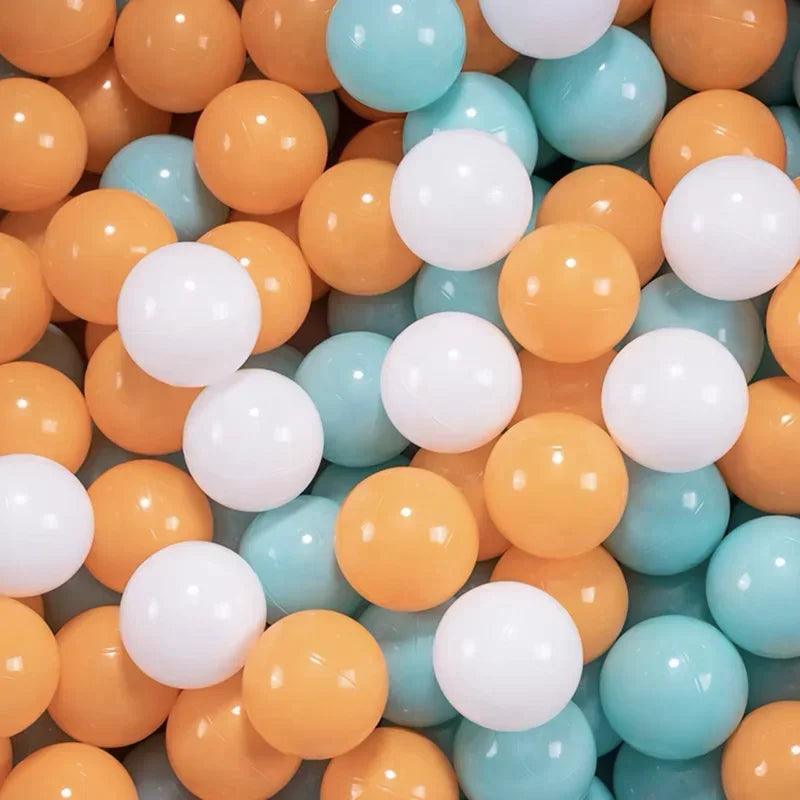 A large collection of colorful plastic ball pit balls in shades of orange, yellow, and light blue.