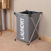 A gray foldable laundry basket with a metal frame is standing on a light carpet.
