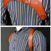 A close-up of genuine leather double shoulder suspenders worn over a blue striped shirt.
