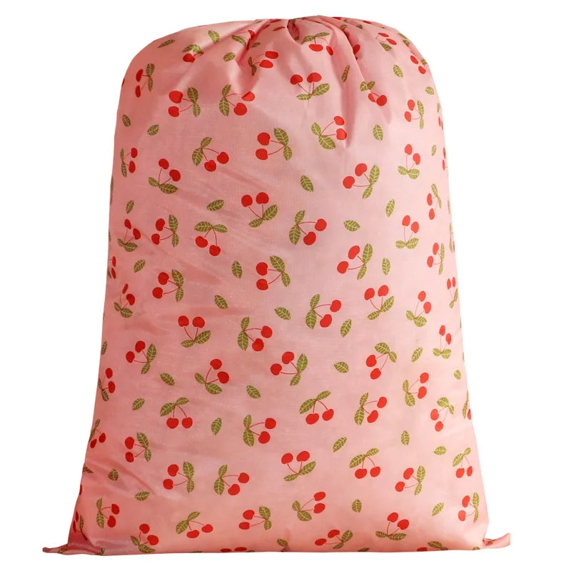 A pink drawstring laundry bag patterned with small red and green berries.