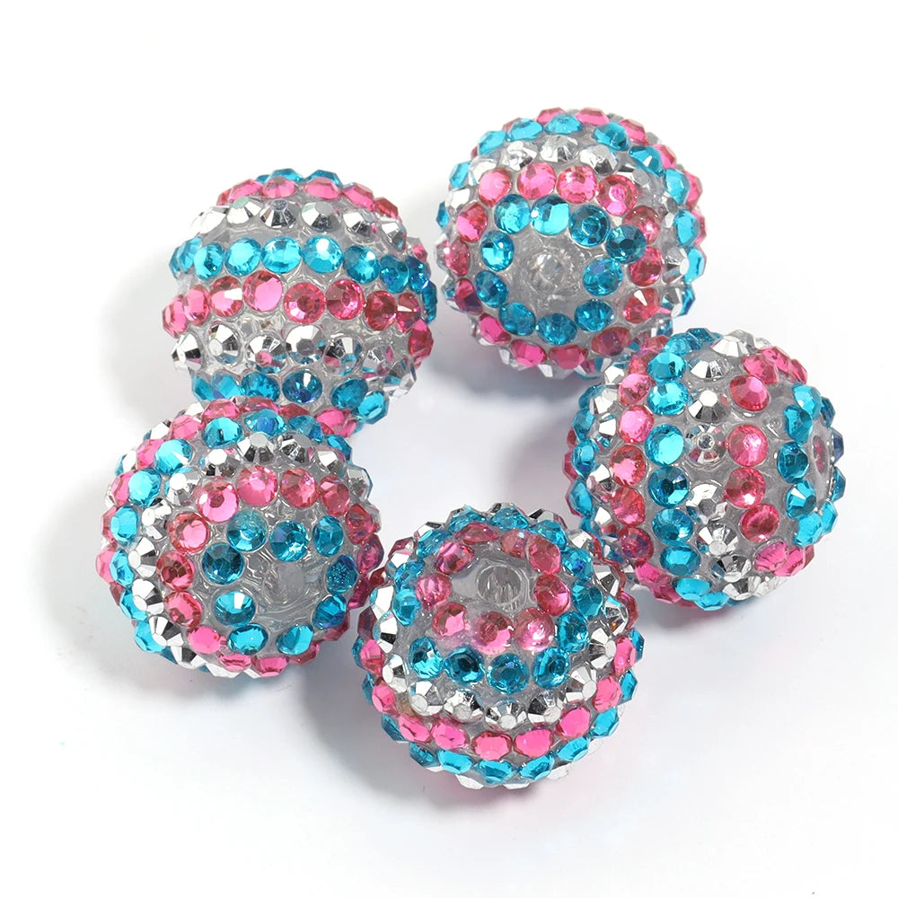 A set of five resin rhinestone beads with a two-tone pink and blue striped design.