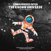 Embroidered patch of an astronaut figure in orange and white against a dark starry background