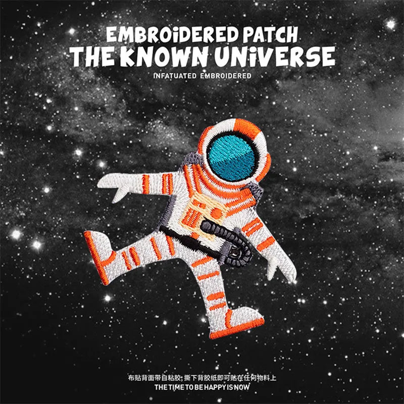 Embroidered patch of an astronaut figure in orange and white against a dark starry background