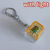A silver chain keychain featuring a clear plastic housing with an LED light and custom keycaps.