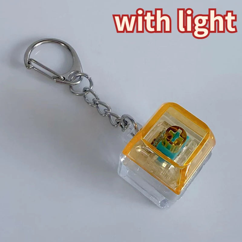 A silver chain keychain featuring a clear plastic housing with an LED light and custom keycaps.
