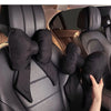 Black butterfly bow tie neck pillow with a black fabric cover shown in a car seat interior.