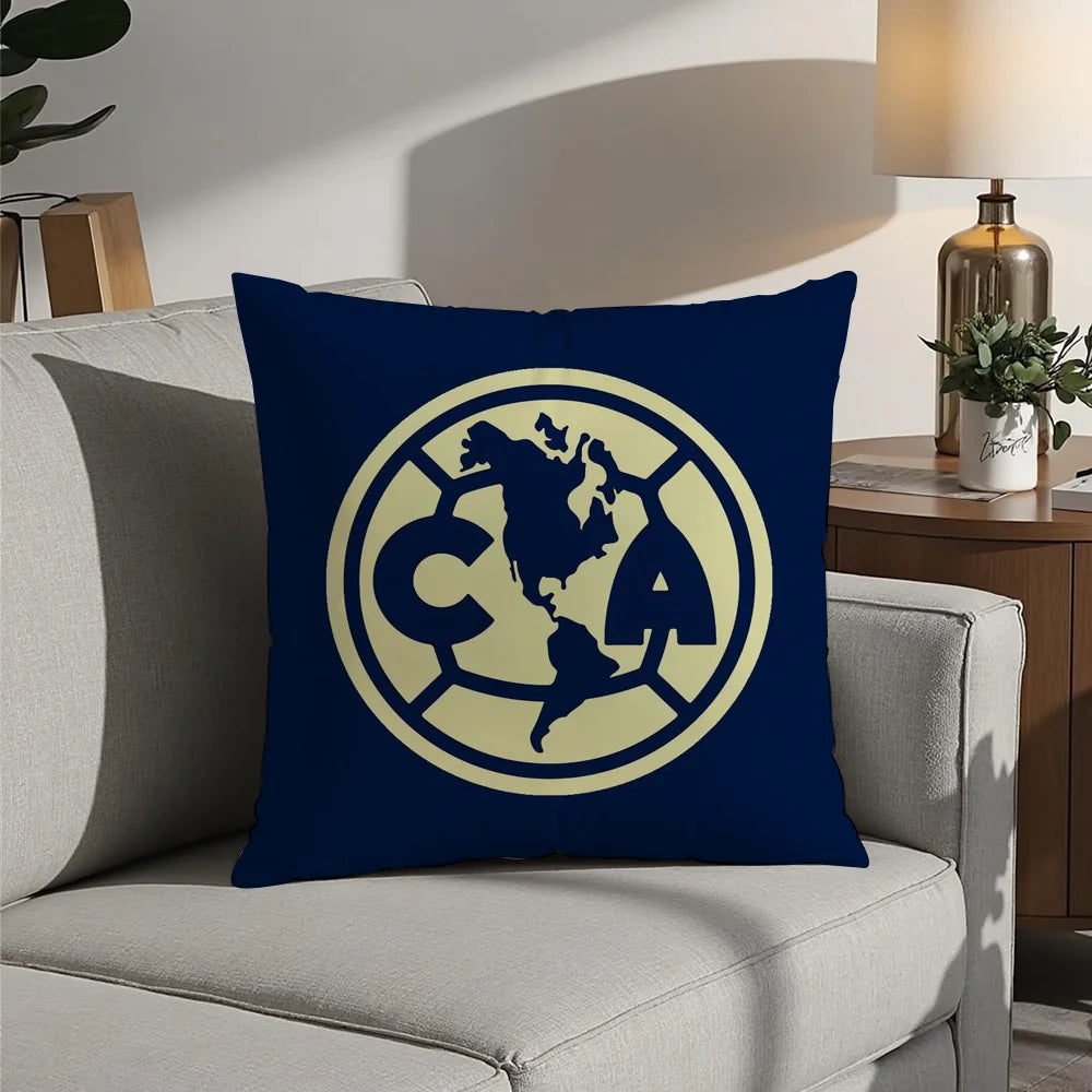 A navy blue decorative pillow featuring a gold-colored circular logo with the letters CA and a map of North America.