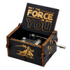 A dark wooden music box with an engraved lid featuring the text May The Force Be With You