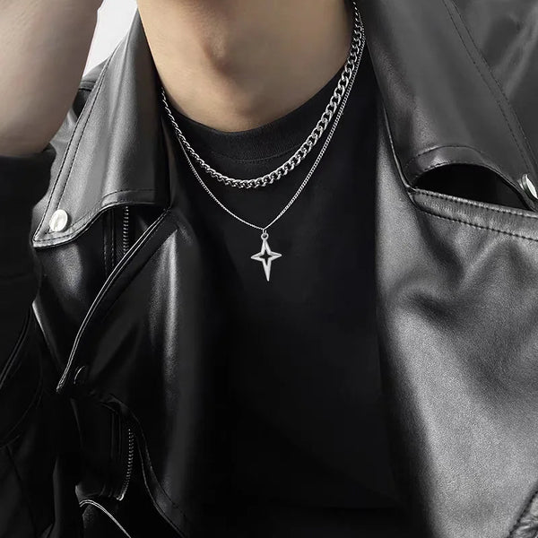 Gros plan d'un collier en étoile cubaine en titane porté autour du cou, superposé à une autre chaîne.