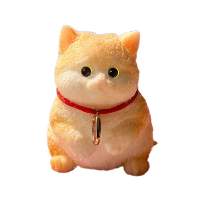 An adorable, fluffy orange cat squeeze toy with yellow eyes and a red collar.