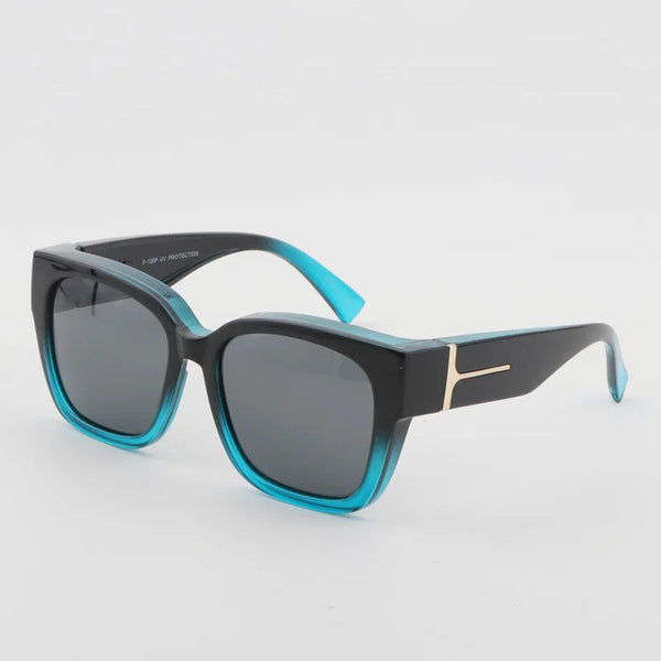 Un par de gafas de sol negras con lentes tintados en verde azulado y un acento dorado, mostradas contra un fondo blanco.