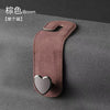 A brown car seat headrest hook with a heart-shaped silicone grip is shown against a dark gray background.
