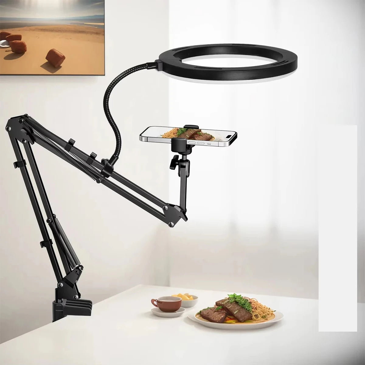 A black adjustable phone stand with an overhead light is positioned above a white table, illuminating food.