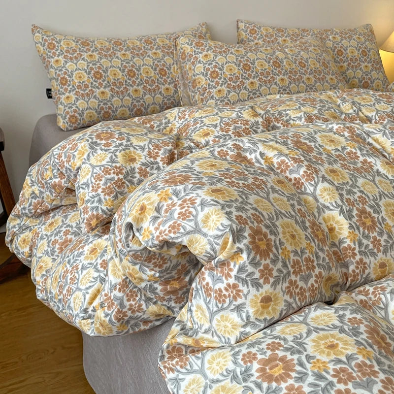A beige and yellow floral printed duvet cover set with matching pillowcases on a bed.