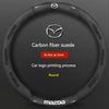 Black carbon fiber suede steering wheel cover with a silver Mazda logo printing process